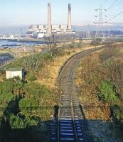 A March 1987 view west from the original Kincardine road bridge showing the town’s two former stations, the rail version in the foreground and the power variety in the background.  At the time, this part of the line had fallen into disuse, but it became more active 10 years later for first coal and then rail engineering traffic after the power station had been closed down and demolished. From 2008 until 2016 it carried considerable coal traffic round the clock for the nearby Longannet power station after the line through Alloa reopened.  <br><br>[Mark Dufton /03/1987]