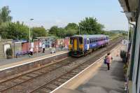 Seen from the now demolished signal box, 153360 calls at Bare Lane with a service from Morecambe to Lancaster on 16th July 2013. The box was no longer controlling trains or the level crossing but was in use as a <I>bothy</I> for platform staff pending installation of electronic platform signs. Ahead of the train the two tracks can be seen to merge but a very short distance further on they diverge again to form the two chords to Morecambe South Junction and Hest Bank.  <br><br>[Mark Bartlett 16/07/2013]