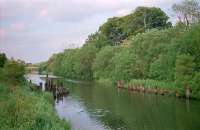 This 1999 view shows the remains of the railway bridge over the Forth and Clyde Canal at Cadder Pits which served the various pits on either side of the canal. A long straggling branch, extended progressively west over several years and then progressively cut back, ran from here to what became Cadder Marshalling Yard. The distant bridge was a temporary works access bridge.<br><br>[Ewan Crawford //1999]