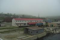 The thriving metropolis that is Zarubino, Far East Russia, photographed from an arriving ferry on 12th June 2013. As can been seen, the place was as dull as the name suggests (I think it was once a state-run fishing port), although it was on a branch line at the eastern extremity of the Trans-Siberian Railway. It really was the end of the world. Railway interest is provided by the blue-liveried Class 20 lookalike loco and a couple of flat wagons trying to hide amongst the buildings on the jetty. The ferry was visiting this outpost of humanity on a trial basis from the South Korean east coast port of Sokcho, up near the border with North Korea, to Zarubino in the hope that Chinese traffic heading for South Korea might be attracted (the Chinese Border isn’t far away from Zarubino).<br>
Taking passage on our northbound ferry were the Osaka branch of Hell’s Angels and their motorbikes (you couldn’t make this up), who were last seen roaring off up the road just visible above the red roofed building in the photo, heading for Vladivostok I believe.<br><br>[Robert Blane 12/06/2013]