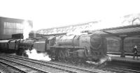 The 8.35am Glasgow St Enoch - London St Pancras standing at a grey and overcast Carlisle station on 1 August 1964. Locomotives are Kingmoor's Britannia Pacific 70003 <I>John Bunyan</I> and  Holbeck Jubilee 45626 <I>Seychelles</I>.<br><br>[K A Gray 01/08/1964]