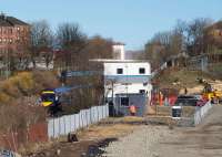  The 10:00 ex-Waverley passes the Fountainwells EGIP depot which is under construction by the side of the line. The depot will be used as a base for the demolition work on the pedestrian overbridge 123 as well as the Queen Street High Level Tunnel Improvement works. Part of the redundant overbridge can be seen above the train.<br><br>[Colin McDonald 07/03/2016]