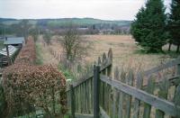 Looking to Ravenswood Junction at Earlston in 1997. The station site had been cleared to become an industrial estate - this railway fence supported by upended rails was the only link with the past. This fence is now gone and the unused land seen here is now 'Station Brae'. The station was behind the camera. In the foreground here had been the end of the loop through the station. [Ref query 3414]<br><br>[Ewan Crawford //1997]