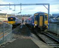 A Motherwell (left) service pulls into Anniesland station simultaneously with a terminating train from Queen Street on 05/03/2016.<br><br>[David Panton 05/03/2016]