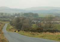 Clapham station (the white building) and viaduct, as seen from the Slaidburn road dropping down from the moor. Clapham village itself is over a mile further along the road, nestling below the trees of the distant hill.  <br><br>[Mark Bartlett 23/03/2016]