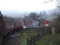 First impressions can be misleading, with BR Standard 76079 appearing to be powering a rake of coaches round a curve. However the smoke tells the truth, being forward of the chimney, as the loco is in fact providing additional propulsion on the rear of a 'Santa Special' being hauled by BR Sulzer D7628 as it approaches Grosmont en route to Glaisdale on Sunday 13 December 2015. The Standard hauled the return working back to Whitby, plus provided ample steam heating to the carriages.<br><br>[David Pesterfield 13/12/2015]