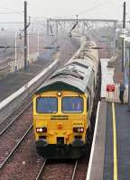 Freightliner 66606 runs through Prestonpans over the re-aligned ECML on 25 April 2003.  The disconnected former route is to the right and rear of the empty cement train.<br><br>[Bill Roberton 25/04/2003]