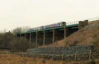 A Morecambe to Leeds service leaves Clapham station (just visible far left) and crosses the substantial viaduct over the River Wenning. The river is a tributary of the Lune but between here and Giggleswick the train will cross the watershed into the Ribble Valley. <br><br>[Mark Bartlett 23/03/2016]