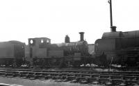 Beattie 2-4-0 Well Tank no 30586 in the disposal sidings at Eastleigh in September 1963. The 1875 locomotive spent its entire BR life working in Cornwall, including the Wenford Bridge mineral line, before being finally withdrawn from Wadebridge shed at the end of 1962. 30586 was cut up at Eastleigh Works in March 1964. [See image 40106]<br><br>[K A Gray 25/09/1963]