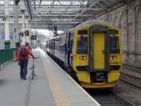 Intermodal.<br><br>
Railscot contributor Bill Jamieson - for it is he - wheels his trusty bike towards 158 867, forming the 13.24 to Tweedbank, at Waverley on 6 April.<br><br>[Bill Roberton 06/04/2016]