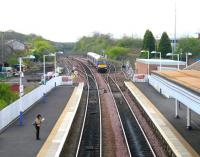 A Dundee train approaching Dalmeny from the Edinburgh direction on 30 April 2005. This train is running non-stop between Haymarket and Inverkeithing. Note the loops and various sidings to the south of the station. The Network Rail engineer's yard on the left is used to hold plant and materials required for maintenance of the Forth Bridge.<br><br>[John Furnevel 30/04/2005]