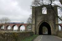 A Clitheroe bound Northern Sprinter passes the ancient Whalley Abbey gatehouse as it slows for the station, which is just at the northern end of the 48 arch viaduct.<br><br>[Mark Bartlett 08/04/2016]