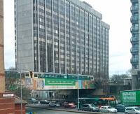 A twin Pacer unit leaves Cardiff Queen Street heading north across Newport Road. The large building in the background is Brunel House built as a regional HQ for British Rail. (It is vertical, despite the distortion from the phone camera).<br><br>[John Thorn 07/04/2016]