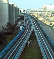 This view from Terminal 2 to Terminal 1 of Taipei Airport in Taiwan shows a compact public transport system known as Skytrain. A train is just visible in the T1 station. One track is for airline passengers only; the other, separated by barriers at each platform, is for general public use. There aren't any rails - shall we call this a guided trainway? [see image 35697]<br><br>[Ken Strachan 27/03/2016]