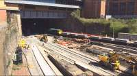 Trackwork has now been laid for the realigned platform 3 in addition to 1 and 2.  The extra few metres added to the north end of platforms one and two can be seen in the V of the concrete base. Meanwhile off to the right, an engineering train loaded with slabtrack sections waits in the platform 7 road.  <br><br>[Colin McDonald 21/04/2016]