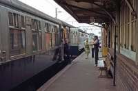 For 100 years, from 1882 to 1982, up carriages from Clacton and Walton were combined at Thorpe le Soken station for forward travel to London. In the down direction, trains were correspondingly divided. This photo, dating from 28th August 1978, shows the supervised coupling of the two London bound portions at Thorpe le Soken, the Walton portion being in the rear nearest the camera. The original platform 1 fell into disuse when this practice stopped.<br><br>[Mark Dufton 28/08/1978]