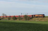 With the downturn in power station traffic the coal wagons are being used for other loads. DBS 66034 takes a rake of hopper empties from Warrington Arpley to Shap Quarry passing Oubeck Loops on 22nd April 2016. <br><br>[Mark Bartlett 22/04/2016]