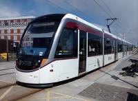 An airport-bound tram at Balgreen on 27/04/2016. The tramstop is on the site of Balgreen Halt at the very start of the Corstorphine Branch.<br><br>
<br><br>
The word depository, on the former Jenner's warehouse in the background, has unfortunate historical associations. The only word I can think of that rhymes with it is similarly infelicitous.<br><br>[David Panton 27/04/2016]