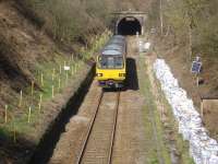 Looking north east from Wellhouse Lane towards the tunnel deep below the A629 Halifax Road linking Sheffield to Huddersfield and Halifax, as Arriva Trains Pacer 144014 exits en route from Huddersfield to Penistone. This is one of the Andrew Barclay built units procured by the former West Yorkshire PTE that was provided with a centre coach. Extensive track and drainage works appear to be on the cards on either side of the road bridge. [Ref query 18843] <br><br>[David Pesterfield 13/04/2016]