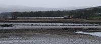 66737 just after passing Ardmore Level Crossing heads east with the empties from Fort William. In the foreground is Ballimenach Yair, one of the six old fish yairs (fish traps) found in this area.<br><br>[Ewan Crawford 15/04/2016]