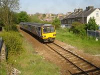 Arriva North three car Pacer 144017 runs west through the site of the former Summer Lane station, closed 1959, shortly after leaving Barnsley on the 14.36 service from Sheffield to Huddersfield on 12 May. The track was previously double and the station had two platforms, with that on the south side, alongside Station Road, containing a long station building. There were also extensive sidings to the west of the station. View from a basic footbridge that has replaced the one that also served the station platforms. [Ref query 2763]<br><br>[David Pesterfield 12/05/2016]