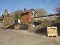 The former coal drops in Helmsley goods yard are still serving their intended purpose some 50 plus years after closure of the line through the town, with the yard and goods shed now occupied by a local coal and log merchant. This May 2016 view is looking north east with the, now  weather-worn, signal box still standing to the south of the station building. Industrial units now occupy the trackbed and surrounding area south from the signal box through to Sawmill Lane.<br><br>[David Pesterfield 09/05/2016]