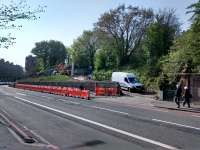 Intriguing works at the site of Murrayfield Station have exposed the approach to the goods yard to better view.  The van is parked on the vehicle approach to the yard which turned right at the nearest of the two new supports (whatever they are for). A goods shed stood end-on to the road above where the red digger is. Meanwhile the passenger stairs, where the couple are passing, are thoroughly overgrown, though for the wooden gate still sports its Scottish Region blue after 54 years.<br><br>[David Panton 11/05/2016]