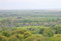 Two DRS Class 66s take the  <I>Tesco Express</I> north through the site of Scorton station (closed 1939) on its way from Daventry to Coatbridge on 16th May 2016. The flat farming land between here and the coast is very noticeable from this vantage point.<br><br>[Mark Bartlett 16/05/2016]