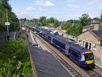 A six-car service from Glasgow Queen Street Low Level to Waverley pulls into Polmont on 24/05/2016. Photographed from the road bridge recently ratcheted-up to accommodate electrification (see advancing masts in background). The footbridge behind me has been electrification-ready for overs 50 years. That's planning.<br><br>[David Panton 24/05/2016]