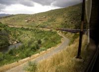 The Cape Gauge (3 foot 6 inch) electric hauled Premiere Class luxury passenger train climbs up from Cape Town into the veldt on 4th November 2005. The train runs overnight to Johannesburg at least two days a week. The consist included a bogie water at the back of the train- for the needs of the passengers, not the engines, of course.<br><br>[Ken Strachan 04/11/2005]