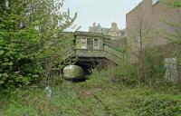 View east of the overgrown platforms and trackbed at Abbeyhill in 1999 showing the now removed street level building and stairs.<br><br>[Ewan Crawford //1999]