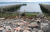 The twin piers and storm damaged approach at Craigendoran in June 2016. The erosion is exposing deeply buried sections of platform edging some of which which have dropped down as seen here.<br><br>[Ewan Crawford 13/06/2016]