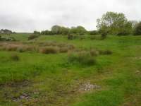 View south from a by-passed section of the A174 coast road showing the trackbed of the former Whitby to Loftus line which ran along a low embankment, after crossing a now removed bridge over the old road, see image 55782, before passing to the rear of properties in Hinderwell village and passing over a level crossing across Browns Terrace before entering the station. It then re-crossed the A174 under a raised road overbridge after leaving the station which was sited alongside the goods yard south of the village [See image 27126].   <br><br>[David Pesterfield 29/05/2016]