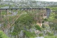 This cantilever bridge was the tallest of its type in the world when built around 1899. In 1969, with heavier trains planned, the bridge was bypassed by a new alignment. Today it is a well known attraction of the narrow gauge White Pass and Yukon Route line.<br><br>[Deon Webber 05/06/2016]