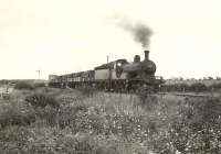 A freight climbing Mormond Hill, Aberdeenshire, on a summer evening in August 1953. The train is hauled by D40 4-4-0 no 62276 <I>Andrew Bain</I>.  <br><br>[G H Robin collection by courtesy of the Mitchell Library, Glasgow 04/08/1953]