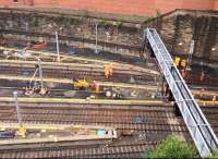 Network Rail's contractors showing their mettle at Queen Street on 4th July 2016: on the left headspan masts, signalling support and an H-beam, and to the right of the new signal gantry, an OHLE cantilever support now gleam in the sunshine.<br><br>[Colin McDonald 04/07/2016]