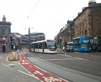 An Edinburgh tram on its way from the airport to the city centre gets the right away ahead of an Airlink bus making the same journey. View west along Haymarket Terrace on 4 July 2016, with Haymarket station on the left.<br><br>[Andy Furnevel 04/07/2016]