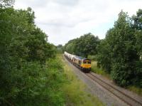 GBRf 66749 heads south, passing under the goods line section of Shay Lane bridge on the former four track Midland Main Line at Walton, near Wakefield. The trainload of silica sand is en route from Middleton Towers, Norfolk, to Monk Bretton glassworks near Barnsley. The view is taken from a footbridge I have not stood on for 50 years, from when I was a member of the Wakefield Railfans Club that rented the ticket office and waiting room, and had free rein of both platforms, at the former Sandal & Walton station. This was from the early 60s to mid 70s when still a fully operational line for many years with both express passenger and fast goods working through the platforms. [Ref query 12838]<br><br>[David Pesterfield 13/07/2016]