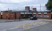 Exterior of Wigan North Western seen on 30/06/2016. The building is of 1972 vintage and shows all the architectural flair of that era. It is so close to Wigan Wallgate they could almost be the same station. The lay passenger may wonder why they are not, or why this station is called 'North Western' despite not being in the north west of Wigan. Tragically people like us know why.<br><br>[David Panton 14/07/2016]