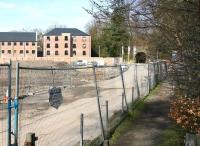 Trackbed of the Penicuik branch looking west towards Auchendinny Tunnel in April 2013. On the left lie the remains of the recently demolished Dalmore Paper Mill, with new housing already beginning to take over the site. <br><br>[John Furnevel 20/04/2013]