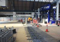 The works at Queen Street seen through the viewing area window on 21st July 2016.<br>
To the left, the platform extension preparations [see image 55605] have been covered up by the temporarily restored concourse and platform barriers are being refitted.<br>
Customers who have been treated to a wide variety of construction noises while passing through the station in recent weeks are currently able to enjoy a selection of aromas from the resurfacing work. <br><br>[Colin McDonald 21/07/2016]