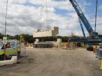 One of the completed bridge abutments for the replacement bridge across Haigh Lane is being lifted from its casting position, prior to start of assembly of these and the deck to create a complete bridge unit ready to be moved to position and lowered onto solid concrete footings alongside the remaining lower section of the existing stone abutments.<br><br>[David Pesterfield 14/07/2016]