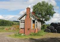 On my last (2010) visit to Moniaive I speculated that the old station building couldn't survive much longer but six years on it clings to life. However, the old goods shed that was in use as a farm building was destroyed in a fire in 2012 and all that remains of that is the tractor access ramp and a pile of rubble. [See image 6593] from 2006.<br><br>[Mark Bartlett 25/07/2016]