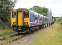 Northern 150220 on the rear of a 4-car Sprinter heading from Colne to Blackpool South pulling away from the stop at Chaffers Siding level crossing. The barriers were previously operated by the driver [see image 17157] but are now automatic. However, trains are still required to stop and ensure the crossing, at the foot of a steep hill, is clear. [Ref query 30873] <br><br>[Mark Bartlett 30/07/2016]