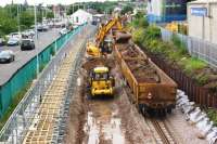 Weekend engineering possession at Chorley on 30 July 2016. In this view north from Lyons Lane bridge towards the station, the down line is being lowered and the temporary platform on the left has been adjusted so that it is clear of the diggers which are loading the train of JNA wagons on the right. The work is in connection with the electrification of the line from Manchester.<br><br>[John McIntyre 30/07/2016]