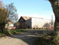 <I>'Oh Grandma... what a big shed you have..' </I> Looking east across Station Road, Ardersier, in October 2005 showing the enormous former HR goods shed, still being put to use 47 years after closure of the branch. The station building, now a private residence, stands just off picture to the left.<br><br>[John Furnevel 31/10/2005]