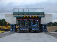 All ready for the move into its permanent location the next day, with the heavy lift vehicle in position below it, is the fully fitted out new concrete bridge assembly that is to replace the present low stone arched Haigh Lane rail overbridge in a 52 hour weekend line closure.<br><br>[David Pesterfield 05/08/2016]