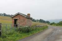 An old permanent-way hut of the Dornoch Light Railway still stands alongside the road at Skelbo, long after the track bed itself has disappeared under the farmland. This view, alongside Loch Fleet, looks towards Cambusavie and The Mound on 20th July 2016. <br><br>[Mark Bartlett 20/07/2016]