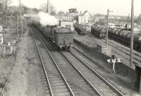 V1 67621 at Bowling on 19 April 1957 with a train for Helensburgh Central. The train has just passed below the L&D route, with its gantry mounted signal box visible in the background. The location is just east of Bowling station on the Caledonian and Dumbartonshire Junction Railway.<br><br>[G H Robin collection by courtesy of the Mitchell Library, Glasgow 19/04/1957]