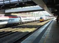 A Pendolino on the down fast passes a Euston-bound set stopped at platform 1. The weather in Stafford is not always so clement [see image 30491]<br><br>[Ken Strachan 16/04/2016]